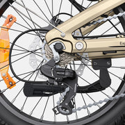 Close-up of a bicycle's rear wheel and drivetrain, showing a Shimano Deore rear derailleur, chainring, disc brake, and a gold-colored frame against a light gray background.