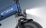 Close-up of an electric bike with a blue frame and 'ENGWE' branding, featuring a headlight on a gray background.