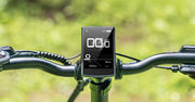 Digital display on a bicycle handlebar with a blurred green background