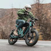 Person riding a motorcycle on a road with mountains in the background